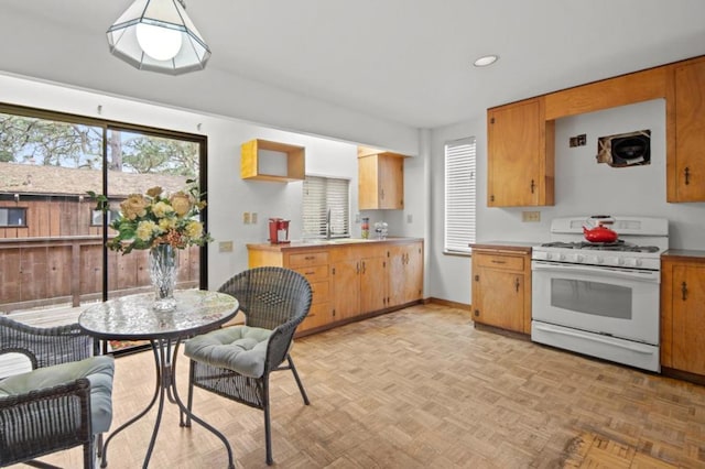 kitchen with light parquet floors, sink, and gas range gas stove