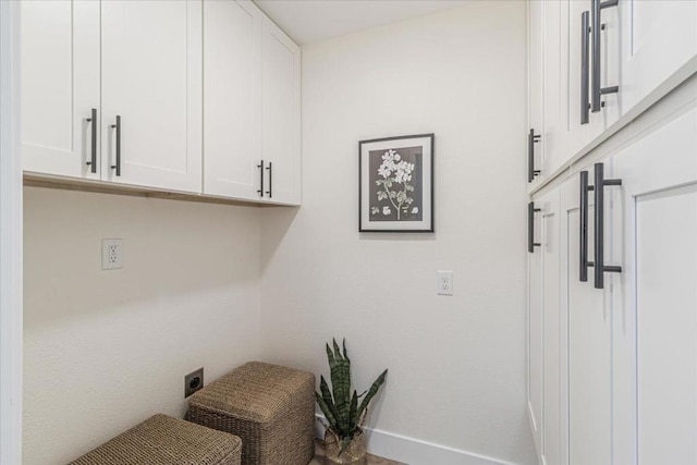 clothes washing area featuring cabinets and electric dryer hookup