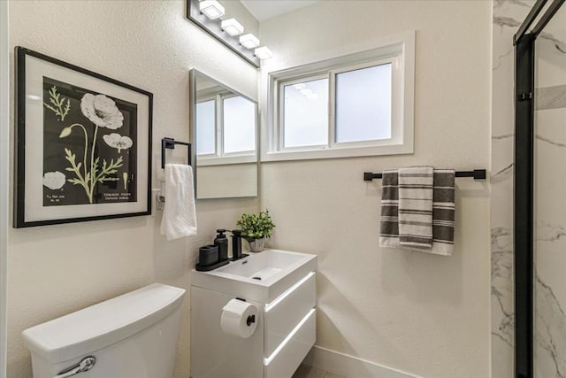 bathroom featuring vanity, walk in shower, and toilet