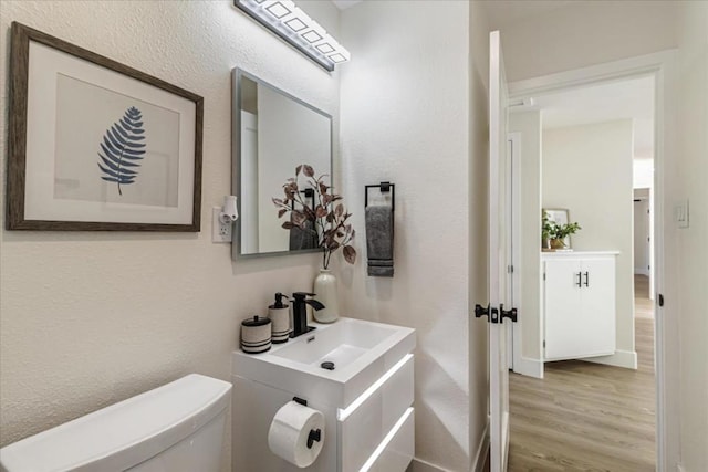 bathroom with vanity, hardwood / wood-style flooring, and toilet