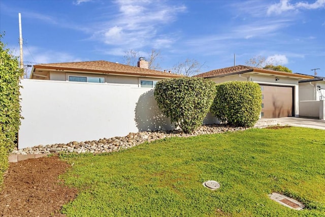 view of front of property featuring a garage and a front lawn