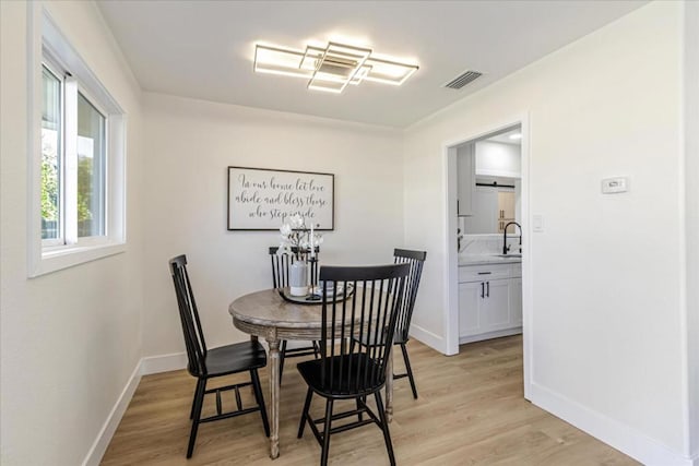 dining area with light hardwood / wood-style floors and sink