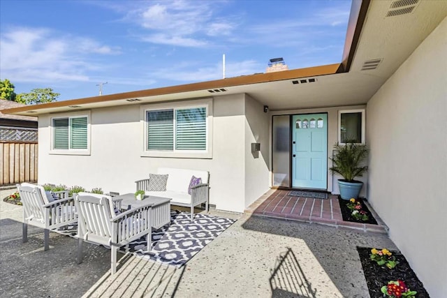 entrance to property with a patio area and outdoor lounge area