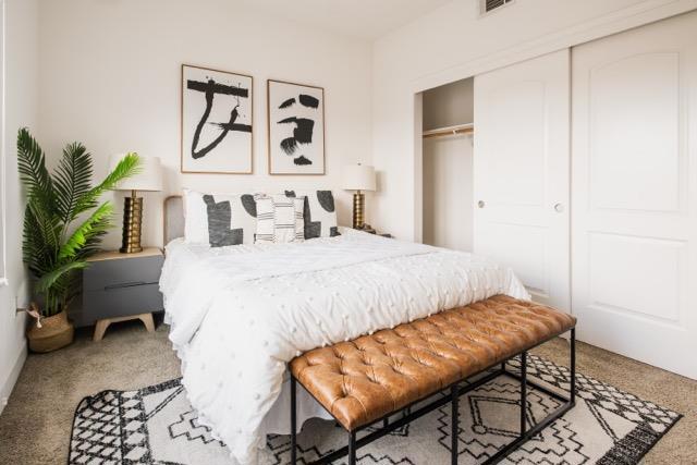 bedroom featuring light colored carpet and a closet