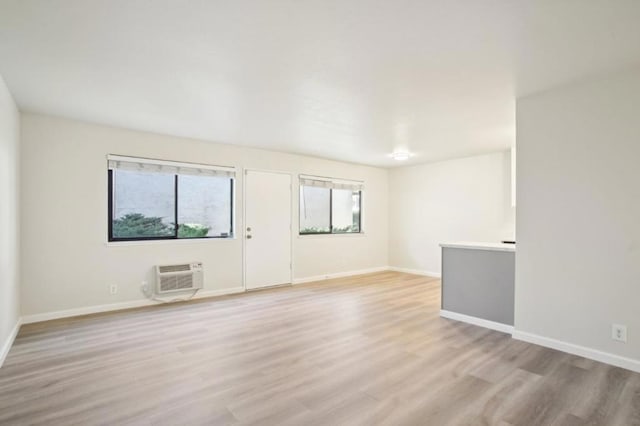 empty room featuring light hardwood / wood-style floors and an AC wall unit