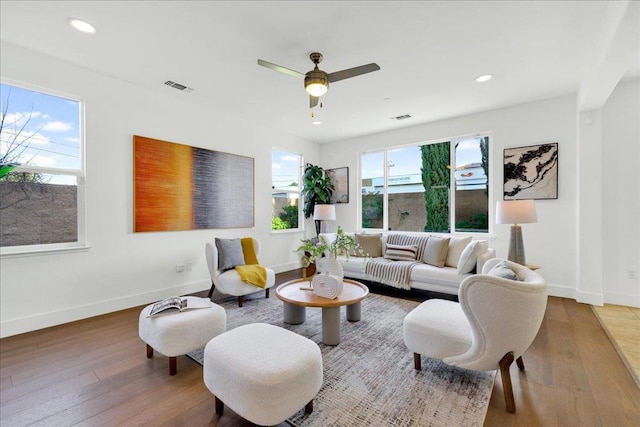 living room featuring wood-type flooring and ceiling fan