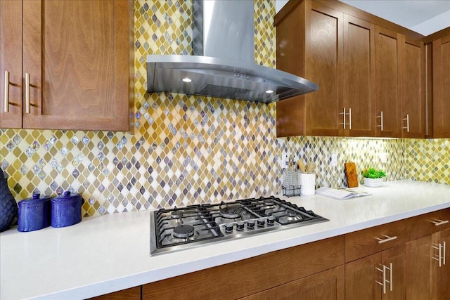 kitchen featuring wall chimney exhaust hood, stainless steel gas stovetop, and decorative backsplash