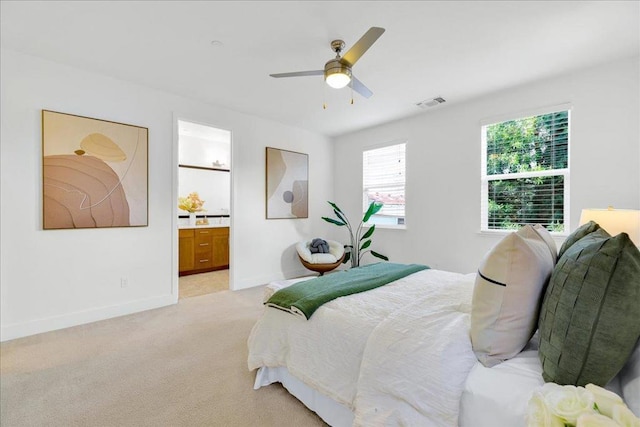 bedroom with light carpet, ceiling fan, and ensuite bathroom