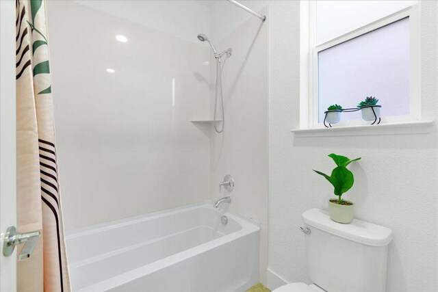 bathroom with shower / bath combination with curtain and toilet