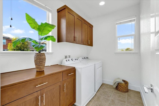 laundry room with cabinets, light tile patterned floors, and washing machine and clothes dryer