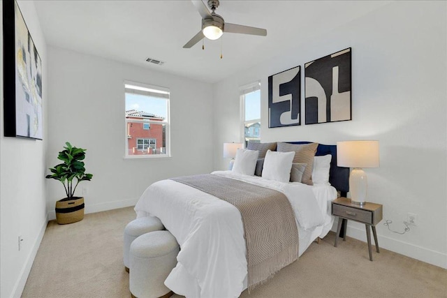 carpeted bedroom with multiple windows and ceiling fan