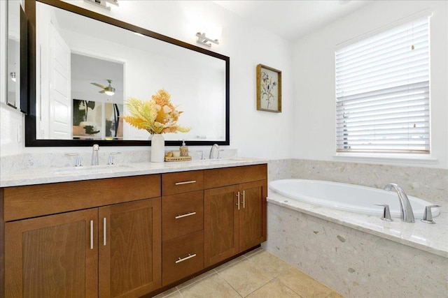 bathroom with tile patterned flooring, vanity, ceiling fan, and tiled tub