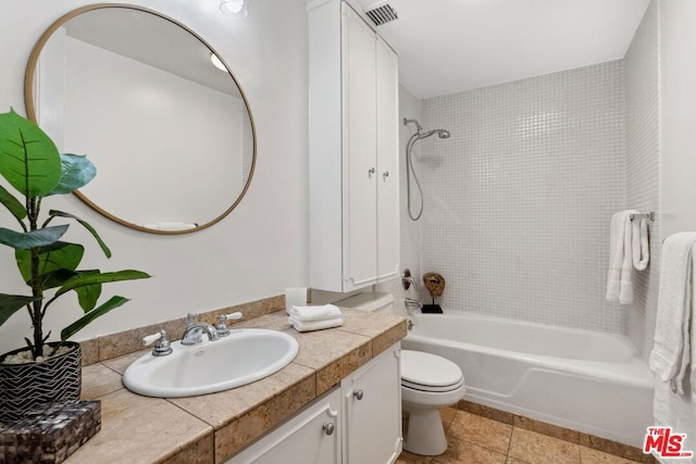 full bathroom with vanity, toilet, tiled shower / bath combo, and tile patterned flooring