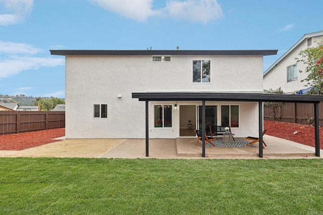 rear view of property with a patio area, a fenced backyard, and stucco siding