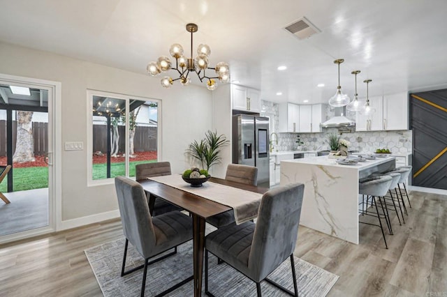 dining area featuring light wood finished floors, baseboards, visible vents, and recessed lighting