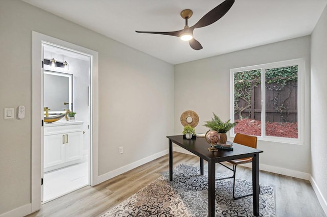 home office with light wood-type flooring, ceiling fan, and baseboards