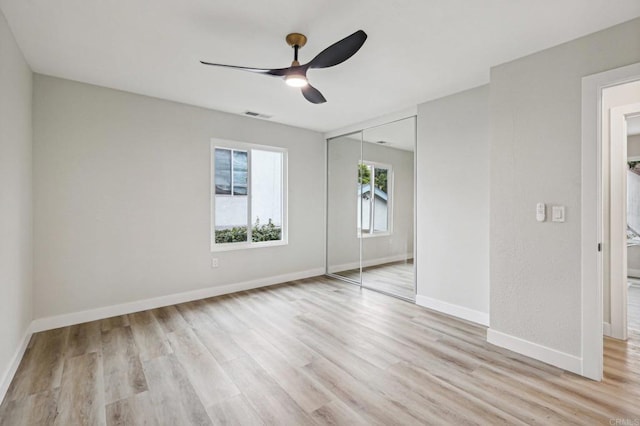 unfurnished bedroom with light wood finished floors, a closet, visible vents, and baseboards