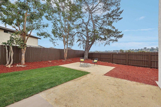 view of yard featuring a patio, an outdoor fire pit, and a fenced backyard