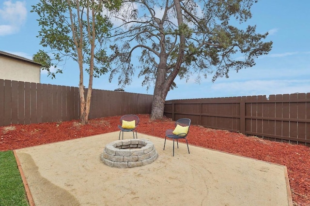 view of patio featuring a fenced backyard and a fire pit