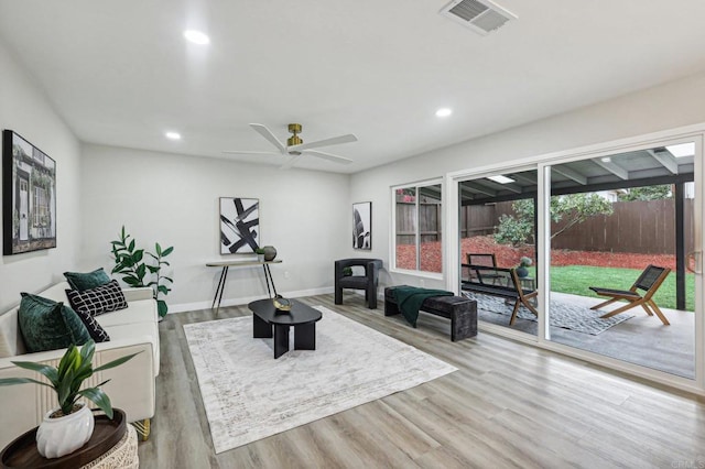 living room featuring light wood-style floors, recessed lighting, visible vents, and baseboards