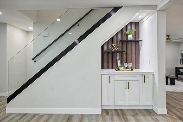 bar featuring light wood-type flooring, baseboards, and recessed lighting