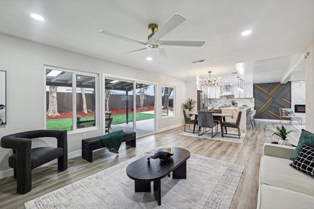 living room featuring baseboards, light wood-style flooring, and recessed lighting