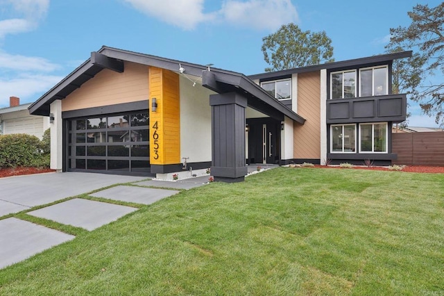 view of front facade with a front yard, fence, and an attached garage