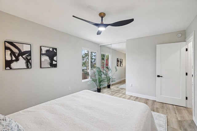 bedroom with light wood-style floors, a closet, baseboards, and a ceiling fan