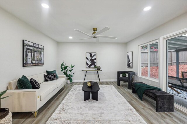 living room with a ceiling fan, recessed lighting, baseboards, and wood finished floors