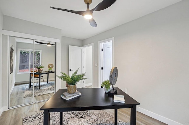 home office featuring ceiling fan, baseboards, and wood finished floors