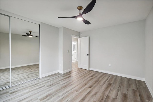 unfurnished bedroom with light wood-style floors, a closet, ceiling fan, and baseboards