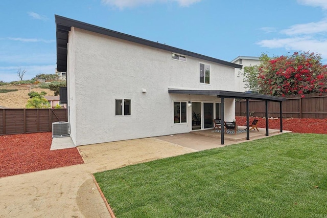 rear view of house featuring a fenced backyard, a patio, and stucco siding