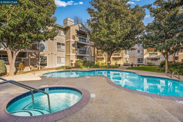 view of swimming pool featuring a hot tub