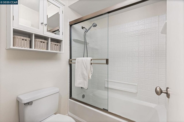 bathroom featuring enclosed tub / shower combo and toilet