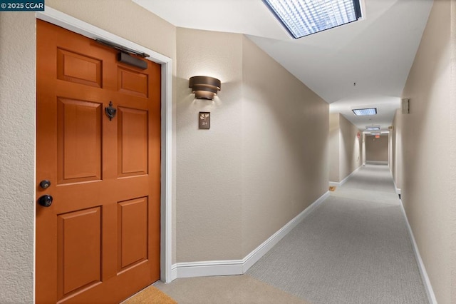 hallway featuring light colored carpet