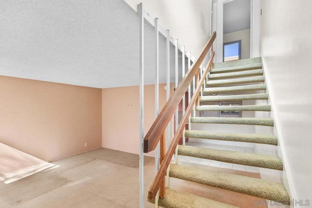 stairway featuring carpet flooring