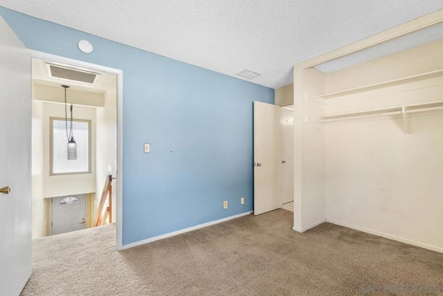 unfurnished bedroom featuring carpet flooring, a textured ceiling, and a closet