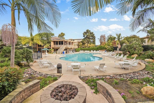 view of swimming pool with a patio and a fire pit