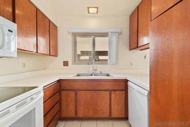 kitchen featuring white appliances, sink, and light tile patterned floors