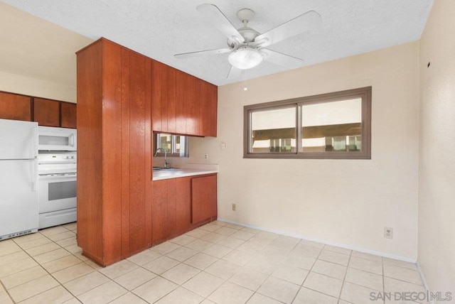 kitchen with sink, white appliances, light tile patterned floors, ceiling fan, and a textured ceiling