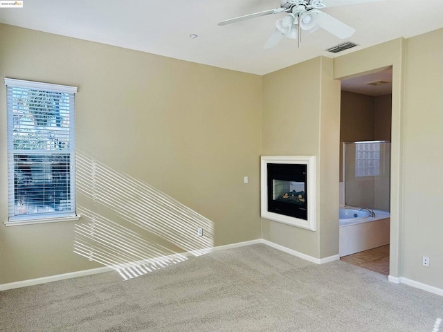 unfurnished living room with ceiling fan and light colored carpet