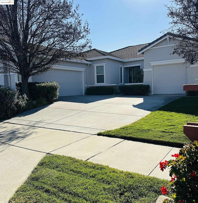 ranch-style home featuring a garage and a front lawn