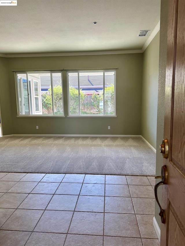 unfurnished room featuring crown molding and light carpet