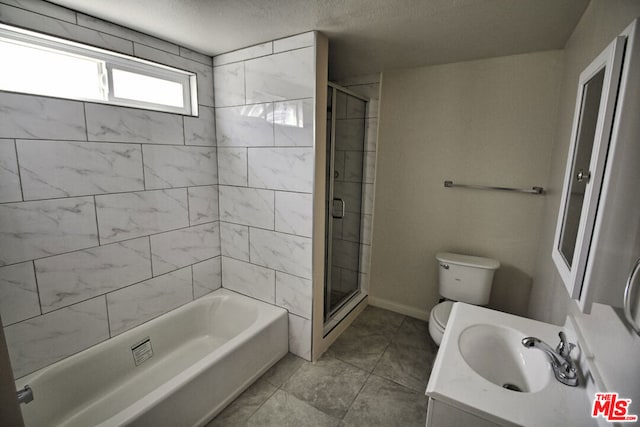 full bathroom featuring sink, a textured ceiling, shower with separate bathtub, and toilet