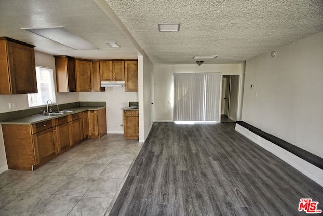 kitchen featuring sink, light hardwood / wood-style floors, and a textured ceiling