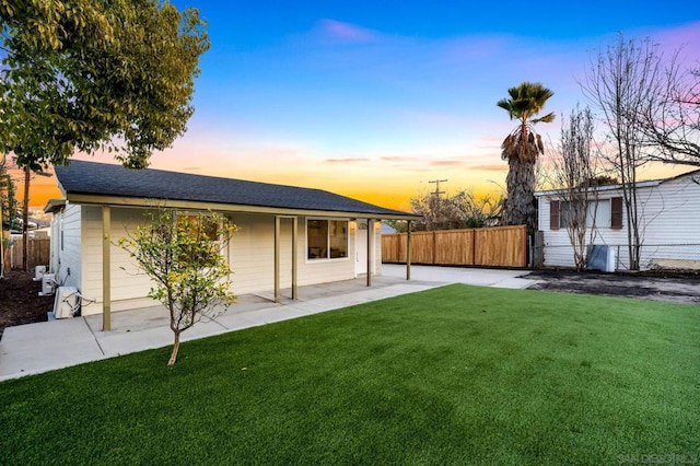 back house at dusk with a yard