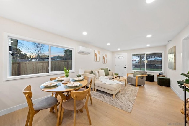 living room with light hardwood / wood-style floors and a wall mounted AC