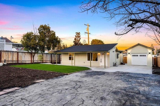 single story home featuring a garage and a yard