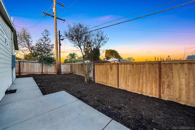 yard at dusk with a patio area