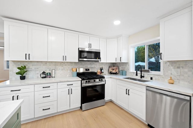 kitchen with white cabinetry, stainless steel appliances, and sink